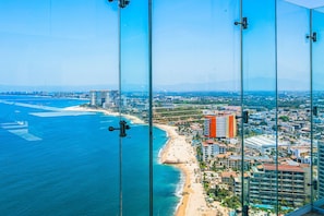 A coastal cityscape with a beach, high-rise buildings, and clear skies. - Oceanfront 1BR Puerto Vallarta condo w/ pool, gym (Puerto Vallarta)