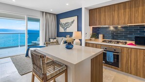 A modern kitchen with wooden cabinets, a white countertop, and a view of the sea. - Summer Deal 1BR Puerto Vallarta condo w/ pool, gym (Puerto Vallarta)