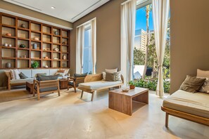 Ein modernes Wohnzimmer mit einem Bücherregal aus Holz, einer Couch, einer Bank und einem Couchtisch.