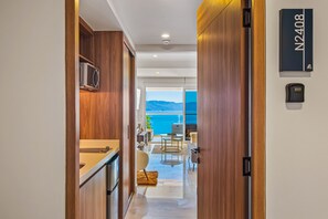 Ein moderner Hotelkorridor mit Holzwänden, einer Küchenzeile und Blick auf das Meer.