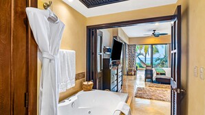 A modern bathroom with a large bathtub, a wooden door, and a view of a balcony with a hammock. - Beachfront dream retreat with pool, tennis & gym access - washer/dryer, AC (Puerto Vallarta)