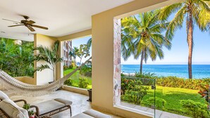 A room with a hammock, wicker furniture, and a view of the ocean and palm trees. - Beachfront dream retreat with pool, tennis & gym access - washer/dryer, AC (Puerto Vallarta)