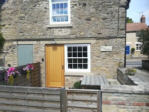A stone cottage with a wooden door, a window, and a sign that reads 'May Cottage.' - May Cottage, Snainton (Scarborough)