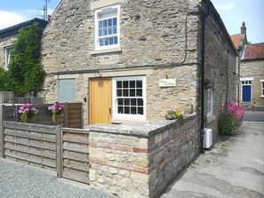 A stone cottage with a wooden door, a window, and a sign that reads 'May Cottage.' - May Cottage, Snainton (Scarborough)