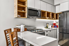 Fridge, microwave, oven, stovetop - Modern condo with rooftop pool, balcony, gas grill & gym access (Puerto Vallarta)