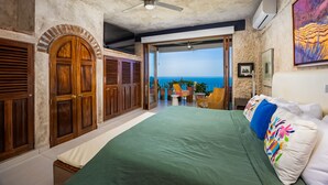 A bedroom with a large bed, wooden wardrobe, ceiling fan, and a view of the ocean. - Paraiso del Mar 1BR/1BA Ocean View in Puerto Vallarta (Puerto Vallarta)