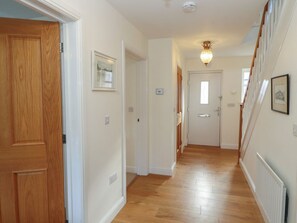 A hallway with wooden flooring, white walls, and a staircase with a wooden railing. - 4 Centurion Rise, Penrith (Penrith)