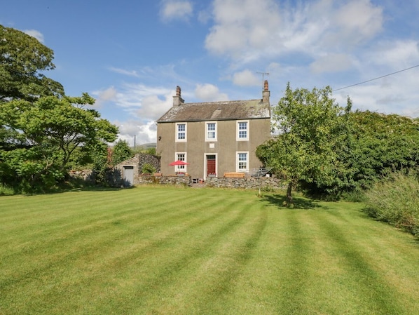 A two-story house with a well-maintained lawn in front.