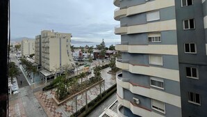 A multi-story building with balconies, a parking area, and a view of the sea. - Terrasol SAN Francisco Larios (Velez-Malaga)