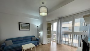 A living room with a sofa, a table, a lamp, and a TV. - Terrasol SAN Francisco Larios (Velez-Malaga)