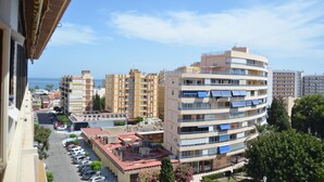 A multi-story building with balconies, a parking lot, and a clear view of the sea. - Terrasol Palma in Torre del Mar (Velez-Malaga)