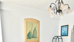Ein Wohnzimmer mit einer Couch, einem Holztisch, einem Beistelltisch mit Lampe und einem gerahmten Kunstwerk an der Wand.