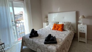 A bedroom with a bed, two bedside tables, a hanging light fixture, and a view through the window. - Terrasol Moriles in Torre del Mar (Velez-Malaga)