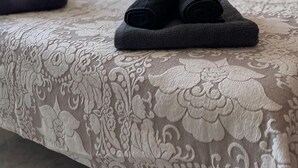 A neatly made bed with rolled towels and an orange pillow. - Terrasol Moriles in Torre del Mar (Velez-Malaga)