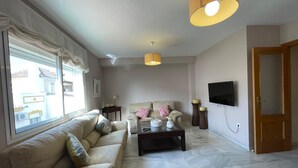 A living room with a sofa, coffee table, and two lamps. - Terrasol Moriles in Torre del Mar (Velez-Malaga)
