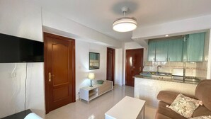 A modern apartment with a living room, kitchenette, and a dining area. - Terrasol California 4 (Velez-Malaga)