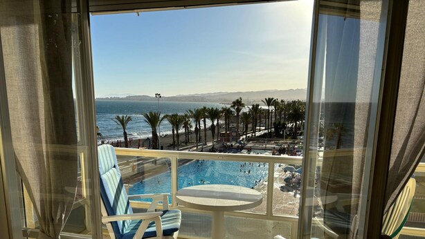 A balcony with a pool, chairs, and a view of the ocean and beach. - Terrasol Sobre EL MAR Habana 4 (Algarrobo)
