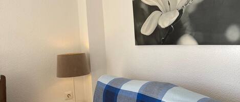 A modern room with a sofa, a lamp, and a wall-mounted air conditioner.