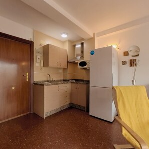 A compact kitchen with a refrigerator, a sink, and a microwave. - Terrasol Plazamar 2-6 (Velez-Malaga)
