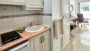 Eine moderne Küche mit weißen Schränken, einem eingebauten Backofen und einer Spüle.