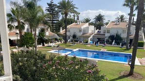 A pool area with a clear view of the surrounding buildings and greenery. - Terrasol Trai AS A1- 1 Linea Playa (Velez-Malaga)