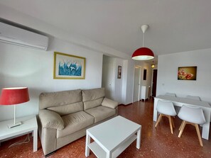 Un salon moderne avec un canapé, une table basse et un coin repas.