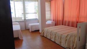 A room with two single beds, a desk, and a television. - Terrasol Caracola 6-b3 (Velez-Malaga)