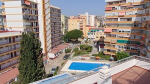 A residential building with multiple balconies, a swimming pool, and a tree in the courtyard. - Terrasol Caracola 6-b3 (Velez-Malaga)
