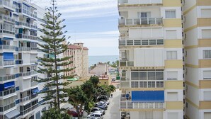 A multi-story residential building with balconies, a parking area, and a clear view of the sea. - Terrasol Caracola 5 in Torre del Mar (Velez-Malaga)