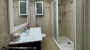 A bathroom with a white sink, a toilet, a shower with a glass door, and two mirrors. - Terrasol Estrella 2 in Torre del Mar (Velez-Malaga)