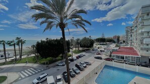 A residential area with a swimming pool, parked cars, and palm trees. - Terrasol Antillas 13 (Velez-Malaga)