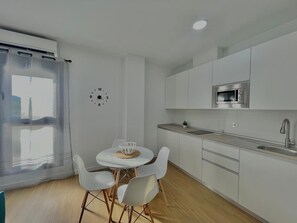 Een moderne keuken met witte kasten, een magnetron en een spoelbak.