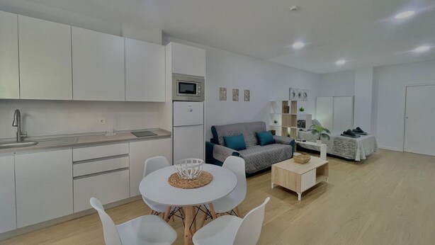 A modern apartment with a kitchen, dining area, and living room. - Terrasol Maenoba Playa 3 (Velez-Malaga)