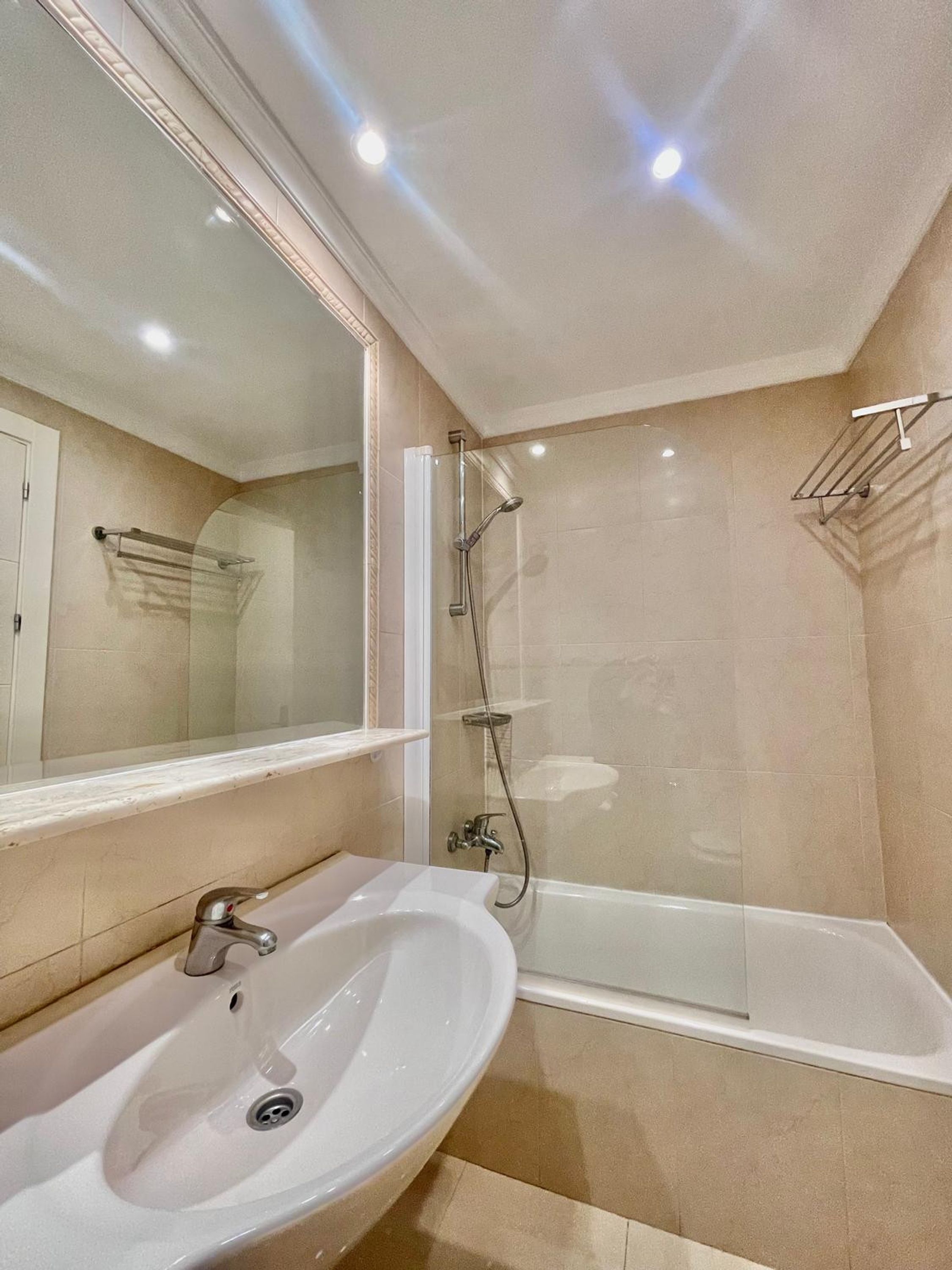 A bathroom with a sink, mirror, shower, and bathtub.