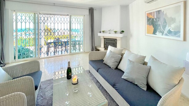 A living room with a sofa, a glass coffee table with a candle, and a fireplace. - Terrasol Villa Independiente Y Apartamento (Velez-Malaga)