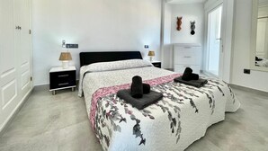 A bedroom with a bed, bedside tables, a wardrobe, and a mirror. - Terrasol Plazamar 2-9-14 (Velez-Malaga)