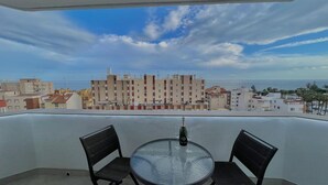 A balcony with a glass table and chairs, overlooking a coastal cityscape. - Terrasol Plazamar 2-9-14 (Velez-Malaga)