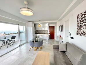 Eine moderne Wohnung mit Balkon, Essbereich, Küche und Wohnzimmer.