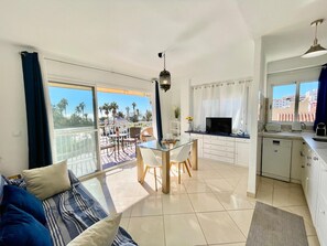 A modern apartment with a balcony, a dining area, a kitchen, and a living room. - Terrasol EL Nido Frontal AL MAR (Velez-Malaga)