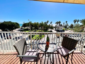 A balcony with wicker furniture, a glass table, and a bottle of champagne. - Terrasol EL Nido Frontal AL MAR (Velez-Malaga)