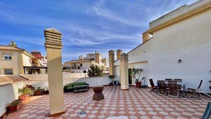 A rooftop terrace with a checkered floor, outdoor seating, and potted plants. - Terrasol Tico Baviera Golf LAS Carmelitas (Velez-Malaga)
