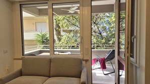 A room with a sofa, a sliding glass door leading to an outdoor balcony with a chair and a table. - Located in one of Viareggio’s most desirable areas, just a few steps from the Pineta di Ponente and approximately a 10-minute walk from the beach, the apartment is an ideal choice for those seeking tranquility and comfort in a well-serviced residential (Viareggio)