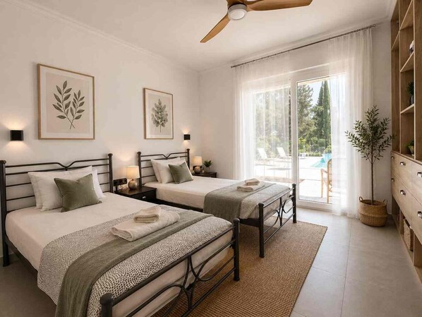 A double room with two beds, a ceiling fan, a large window with a view of the outdoors, and a plant.