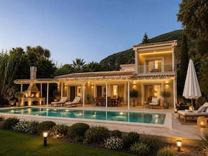 A two-story house with a swimming pool, outdoor seating, and a barbecue area.