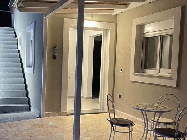 A staircase leading to a room with a door, a window, and a small table with chairs.