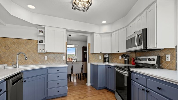 A modern kitchen with white cabinets, a built-in oven, a microwave, and a dishwasher. - The Lake House on Boyd Private Boat Ramp & Dock (Loveland)