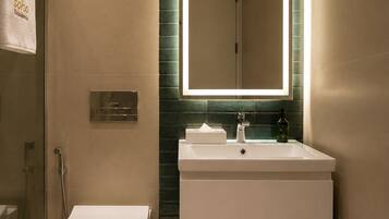 A modern bathroom with a toilet, sink, and mirror.