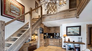 Una cocina amplia con armarios de madera, una isla central y un comedor con mesa de madera.