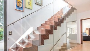 Un escalier moderne avec des rampes en verre et des marches en bois.