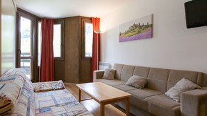 Una sala de estar con un sofá, una mesa de centro de madera y un sofá beige.
